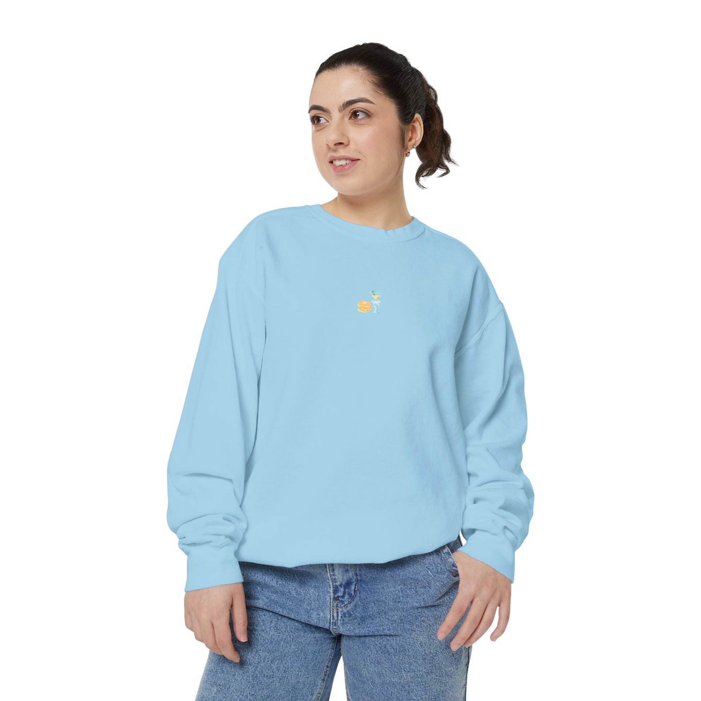 Woman wearing light blue Hanukkah sweatshirt featuring embroidered stack of latkes and martini design at center chest