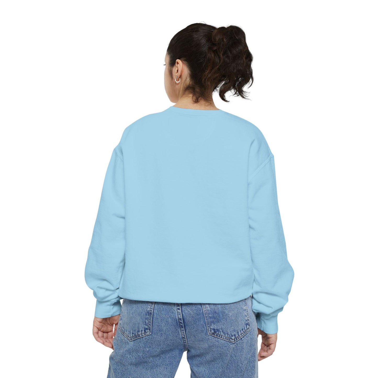 Back view of a woman wearing a light blue Hanukkah sweatshirt with jeans