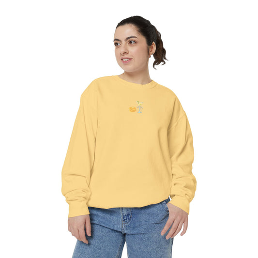 Woman wearing a yellow sweatshirt with a small embroidered Hanukkah design with jeans