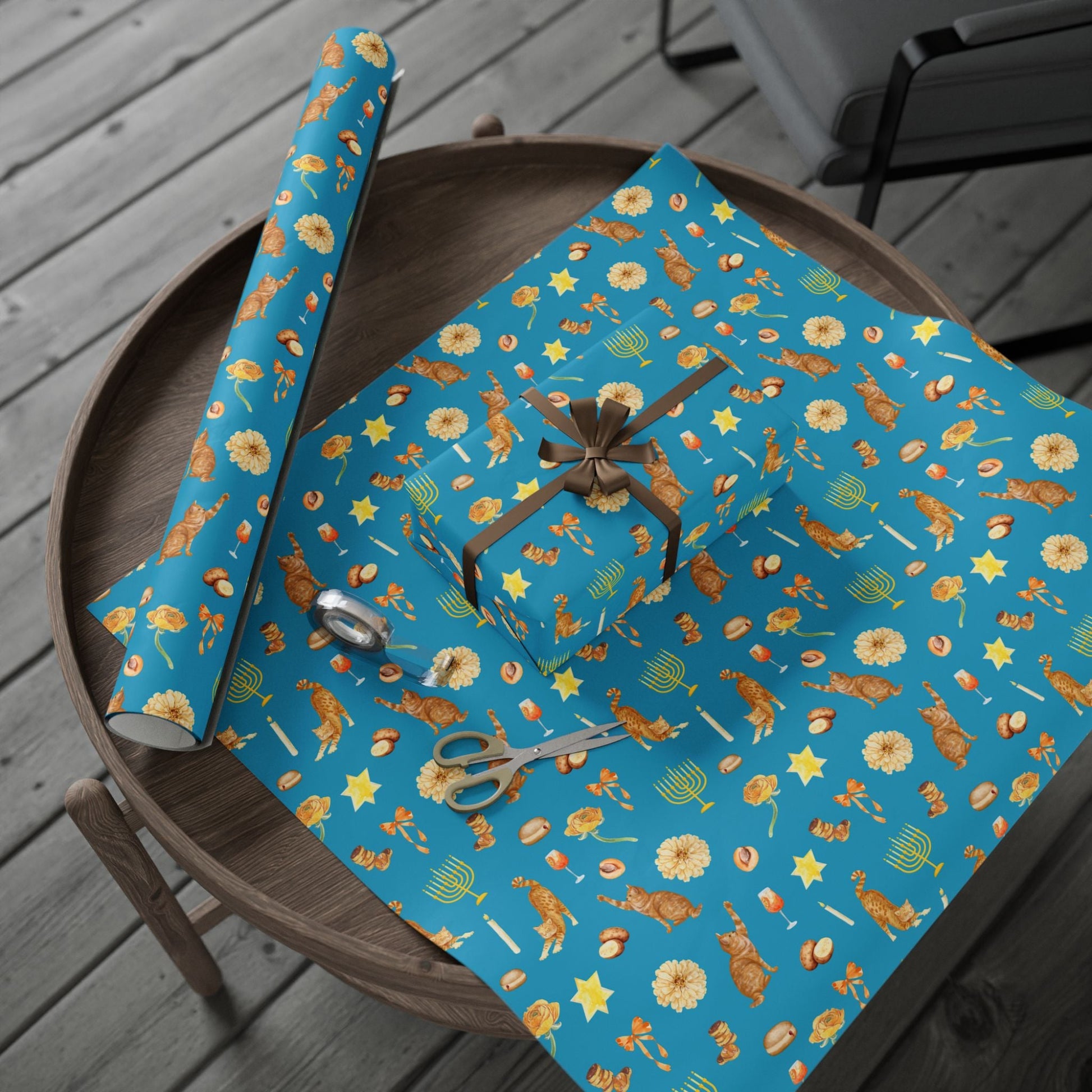 Blue Hanukkah gift wrap in festive print with orange cats and golden menorahs