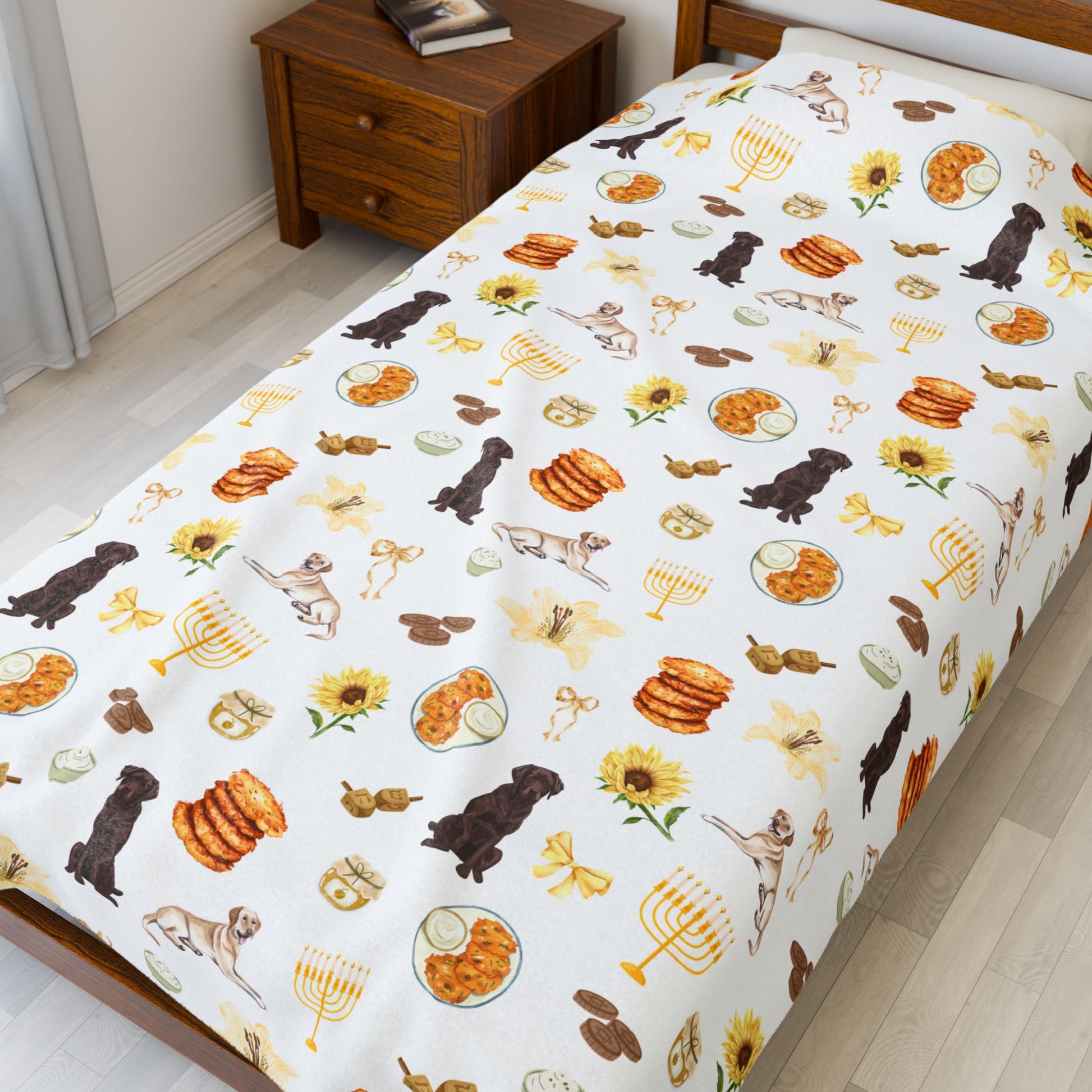 Large throw blanket with Hanukkah-themed pattern featuring dogs, latkes, and sunflowers on a twin bed