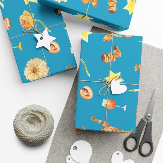 Blue gift wrap with floral and cat pattern on a white surface with scissors and yarn