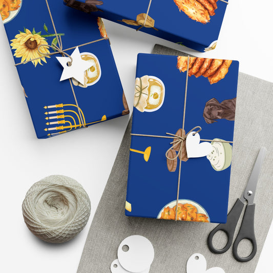 Hanukkah gifts wrapped in printed paper featuring labrador retriever dogs, latkes with applesauce and sour cream, menorahs, flowers, and gelt